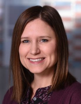 Professional headshot of Dr. Julie Miller, founder of Cincinnati Neuropsychology, smiling against a blurred background.